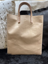 Load image into Gallery viewer, natural vegetable tanned leather bags small size, narrow-rectangular flat shape. two veg tan handles attached/sewn using belgian linen yarn. also made in distressed brown & black leather and black & tan suede. Retail price $195.