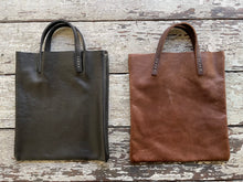 Load image into Gallery viewer, Black and brown leather bags small size, narrow-rectangular flat shape. two veg tan handles attached/sewn using belgian linen yarn. also made in natural vegetable tanned leather and black & tan suede. Retail price $195.