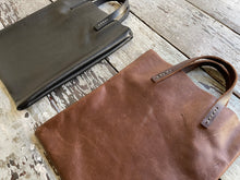 Load image into Gallery viewer, Black and brown leather bags small size, narrow-rectangular flat shape. two veg tan handles attached/sewn using belgian linen yarn. also made in natural vegetable tanned leather and black & tan suede. Retail price $195.